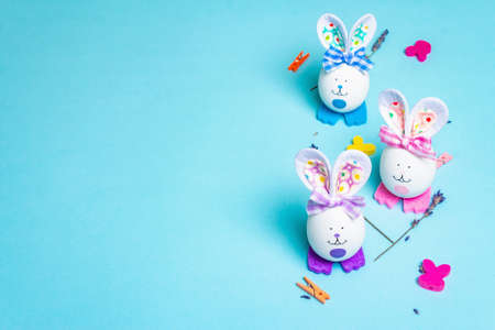Traditional Easter symbols concept. Cute rabbits from eggs, fragrant lavender twigs, and festive decor. Pastel blue backgroundの写真素材