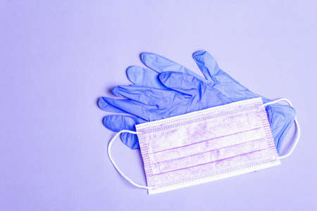 Fashion purple masks and glamor gloves isolated on lilac background. Medical products for personal hygiene and the prevention of viral diseases. Coronavirus, COVID-19 pandemicworldwide conceptの写真素材