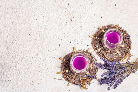 Lavender flower drink. Non alcoholic summer tonic lemonade with dry bouquet. Light plaster background, top viewの写真素材