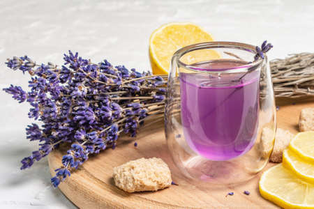 Lemonade with lemons and lavender. A refreshing low alcoholic drink with fresh fruits and a dry bouquet. White putty background, close upの写真素材