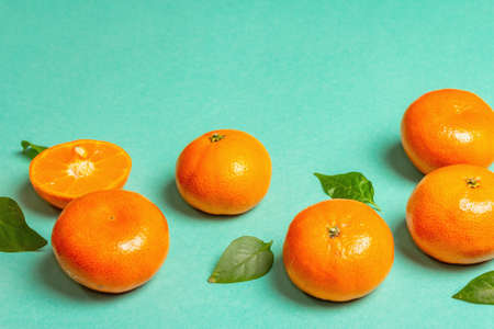 Ripe juicy tangerines and fresh leaves. Sunny summer turquoise backgroundの写真素材