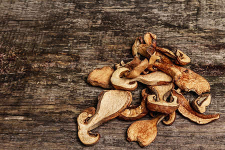 Forest dried edible mushrooms. Dehydrated slices, exquisite ingredient for cooking healthy food. Vintage wooden table, copy spaceの写真素材