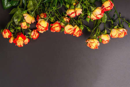 Bouquet of bright yellow-orange roses on black stone background. Festive gift, greeting card for Easter, Birthday, Valentines Day or Wedding. Holiday concept, a place for, top viewの写真素材