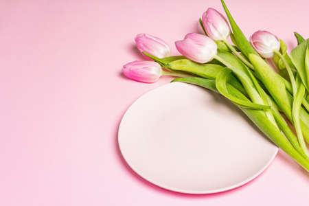 Festive creative pink table setting with tulips on gentle rosy background. Valentine's Day, Wedding, Birthday, Women's, and Mother's Day. Flat lay, copy spaceの写真素材