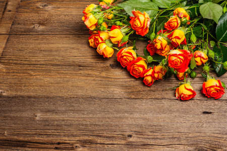 Bouquet of bright yellow-orange roses on old wooden table. Festive gift, greeting card for Easter, Birthday, Valentines Day or Wedding. Holiday concept, a place for textの写真素材