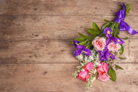 A beautiful bouquet of wedding flowers on old wooden boards. The concept for a holiday gift for Birthday, March 8 or Valentine's Day. Greeting card, a place for text, top viewの写真素材