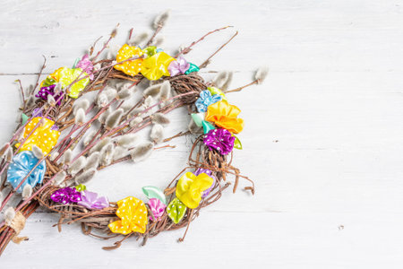 Sprig of willow and braided wreath on old white wooden boards background. Willow seals, fluffy buds, hand made flowers. Happy Easter conceptの写真素材
