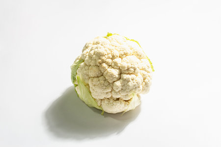 A fresh head of cauliflower isolated on white background. Raw single vegetable, healthy food concept, vegan or vegetarian lifestyle. Trendy hard light, dark shadow, flat lay, mockup, templateの写真素材