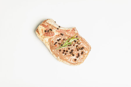 Raw pork loin steak isolated on white background. Fresh garlic, fragrant rosemary, black peppercorn, sea salt. Flat lay, mockup, templateの写真素材