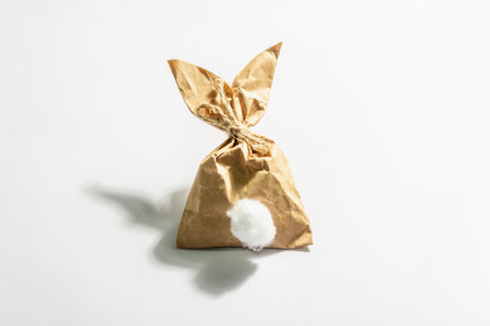 Easter bunny paper gift isolated on white background. Festive Easter symbol, greeting card, DIY concept. A trendy hard light, dark shadow, flat lay, mockup, templateの写真素材