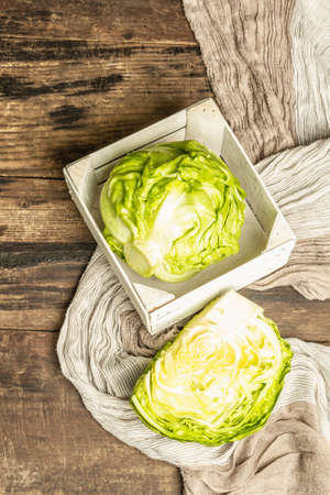 Fresh young cabbage in a rustic arrangement. Wooden crate, linen napkin. Vintage boards tableの写真素材