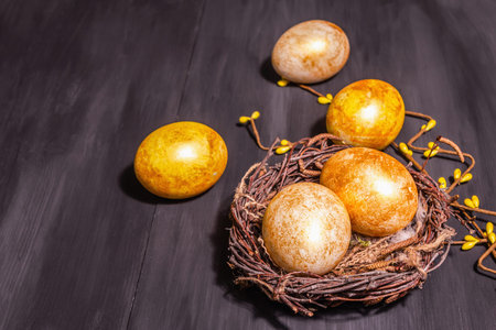 Golden Easter eggs in a wicker nest. Traditional Easter symbol, festive decor. Trendy hard light,...