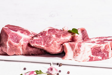 Raw pork meat, sliced cuts. Fresh meat, dry sumac, garlic and basil leaves. Healthy cooking food...