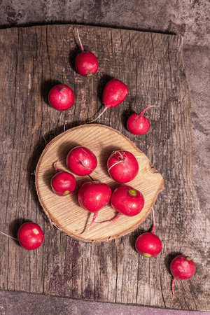 Pink ripe radish on a wooden stand. Fresh sweet vegetables, organic farmer product. Modern hard light, dark shadow, chopping board, marble stone background, top viewの写真素材