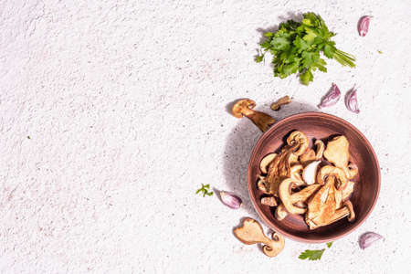 Dried mushrooms Boletus edulis (Penny bun, Cep, Porcini) on textured plaster background. Ingredient for vegetarian (vegan) healthy food. A trendy hard light, dark shadow, top viewの写真素材
