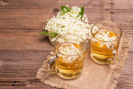 Elderberry flower tea. Refreshing summer drink, healthy lifestyle concept. Sackcloth napkin, vintage wooden table, copy spaceの写真素材