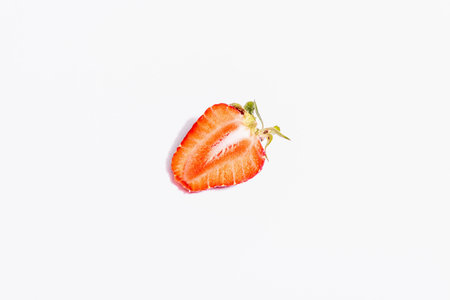 Fresh ripe half strawberry isolated on white background. Sweet summer fruit, healthy food. A modern hard light, dark shadow, top viewの写真素材