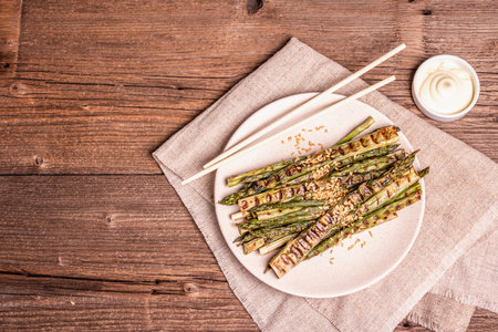 Ripe grilled asparagus. Wooden cutlery, healthy food concept. Trendy hard light, dark shadow. Vintage boards table, top viewの写真素材