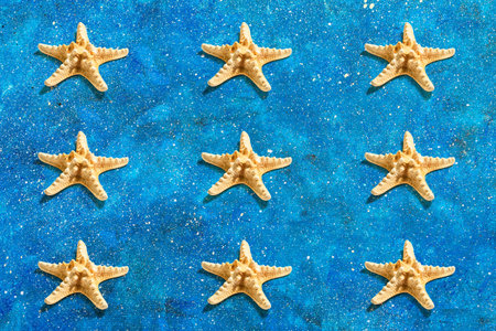 Starfish pattern on a blue nautical background. Vacation concept, sea card. A trendy hard light,...