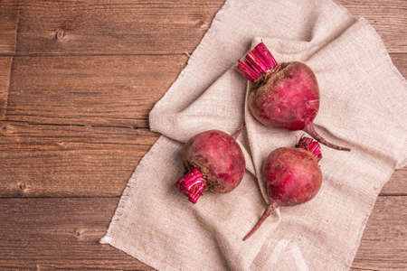 Fresh beetroots on a vintage wooden table. Culinary background, ingredients for preparing wholesome food, top viewの写真素材