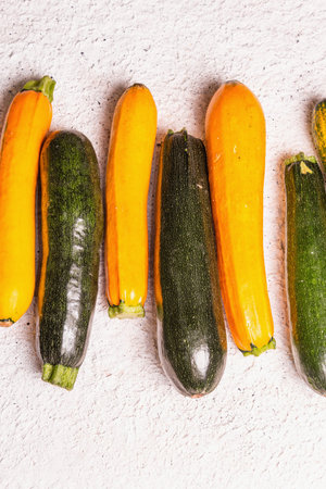 Assorted fresh zucchini. Ripe vegetables harvest on a light plaster background, top view