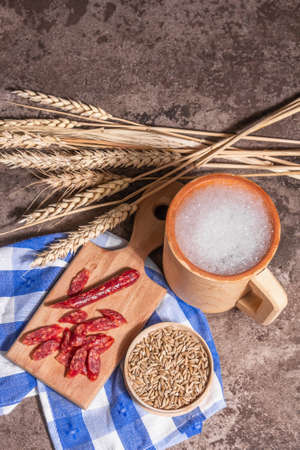 Oktoberfest concept. Beer and grain, sausages, wooden mugs. A trendy hard light, dark shadow, stone concrete background, top viewの写真素材