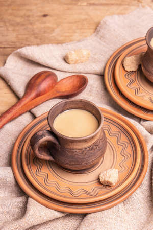 Aromatic coffee in a cozy home style. Ceramic mugs, hot drink, wooden table. Morning, good mood, copy spaceの写真素材