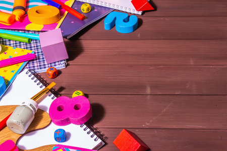School supplies on wooden boards background. Album, notebooks, felt-tip pens, brushes, palette,...
