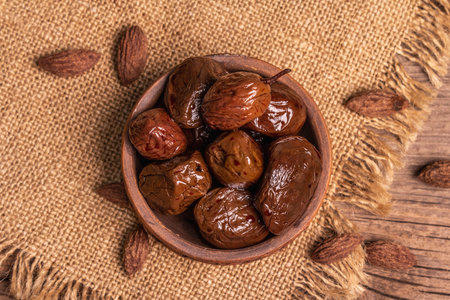 Sun-dried olives in a ceramic bowl. Traditional Greek appetizer, dry seeds, old wooden planks table....