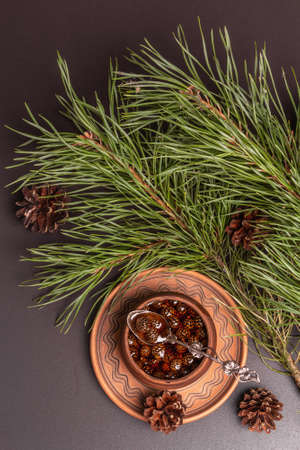 Sweet pine cone jam. Traditional Siberian dessert, fresh evergreen branches. Black stone concrete background, top viewの写真素材