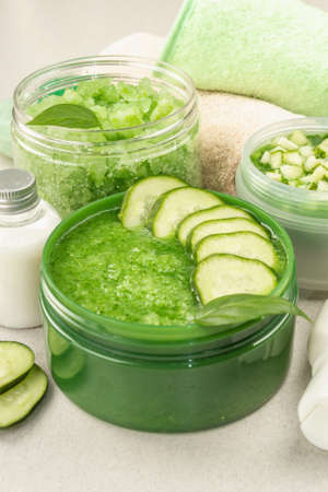 Homemade cosmetics with cucumber. Detoxification skin vegetable masks. Natural cream, sea salt, body lotion, and soap. Light stone concrete background, close upの写真素材