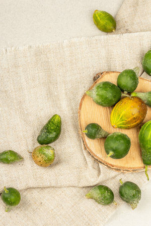 Trendy ugly cucumbers. Cooking organic ugly food concept. Stone concrete background, wooden stand, top viewの写真素材