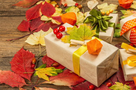 Zero waste gift concept with autumn design. Warm sweaters, fall leaves, thematic decor. Soft light, old wooden boards background, flat layの写真素材