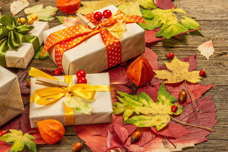 Zero waste gift concept with autumn design. Warm sweaters, fall leaves, thematic decor. Soft light, old wooden boards background, flat layの写真素材