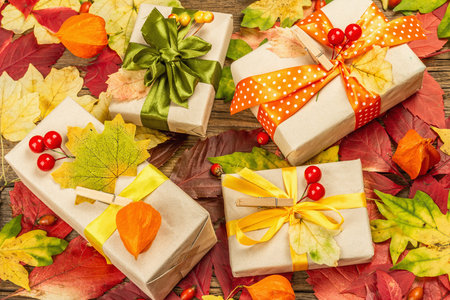 Zero waste gift concept with autumn design. Warm sweaters, fall leaves, thematic decor. Soft light,...