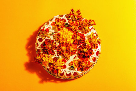 Autumn composition from assorted marigold flowers, isolated on orange background. Floral multicolored assortment, fresh leaves on wicker basketの写真素材