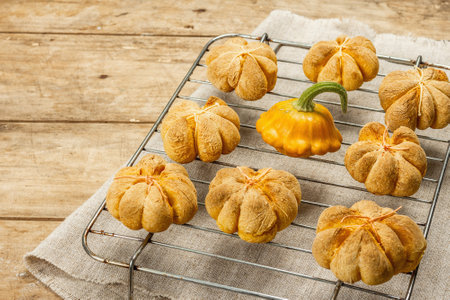 Pumpkin buns or biscuits, traditional fall baked goods. Seasonal homemade food and autumn decor. Old...
