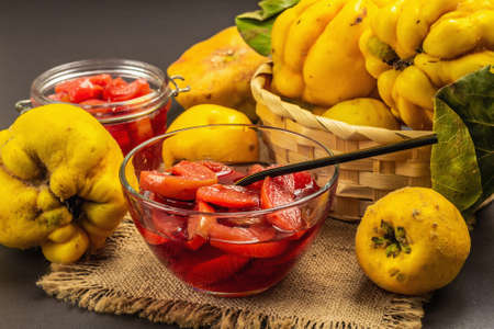 Quince jam or confiture. Ripe whole fruits, sweet dessert, autumn good mood. Black stone concrete background, close upの写真素材