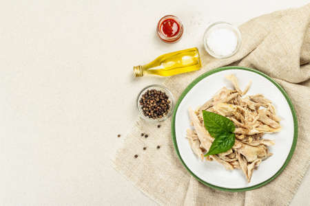 Boiled chicken meat with greens and spices. Low fat animal protein, healthy food lifestyle. Cutlery, natural oil on stone concrete background, top viewの写真素材