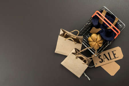 Black Friday Sale concept. Shopping basket, handmade tags, paper bags, and pumpkin cookies. Black...