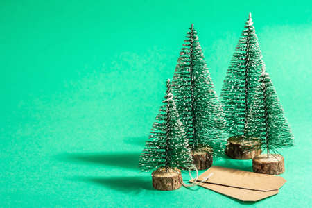 Christmas Sale concept on turquoise background. Decorative fir tree and paper tag.Traditional New Year symbol. A trendy hard light, dark shadow. Flat lay, mockup, template, copy spaceの写真素材