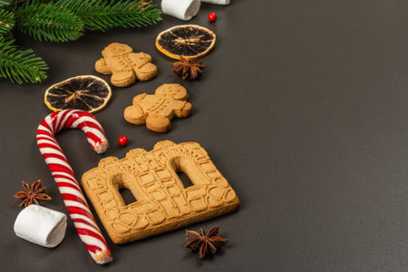 Christmas Gingerbread House cookies biscuit. Traditional festive New Year decor. Black stone concrete background, lifestyle, flat lay, copy spaceの写真素材