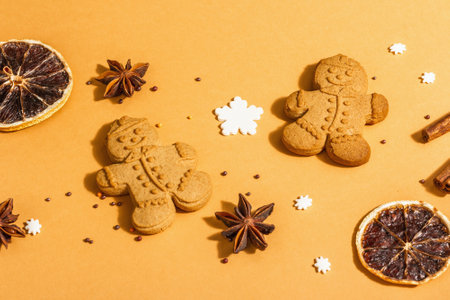 Christmas Gingerbread Men with fragrant spices. Traditional festive New Year decor. Trendy hard light, dark shadow, beige background, flat lay, close upの写真素材