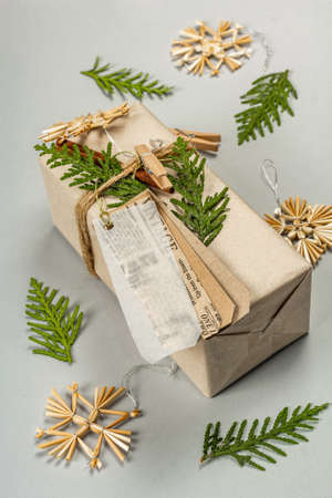 Zero waste gift concept. Christmas or New Year eco-friendly packaging. Festive boxes in craft paper with different organic decorations. Light gray background, flat lay, close upの写真素材