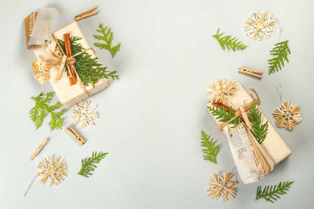 Zero waste gift concept. Christmas or New Year eco-friendly packaging. Festive boxes in craft paper with different organic decorations. Light gray background, flat lay, top viewの写真素材