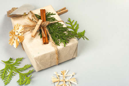 Zero waste gift concept. Christmas or New Year eco-friendly packaging. Festive boxes in craft paper with different organic decorations. Light gray background, flat lay, copy spaceの写真素材