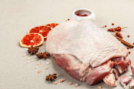 Piece of raw turkey meat with spices. A useful ingredient for preparing healthy food, spices, garlic. Stone concrete background, close upの写真素材