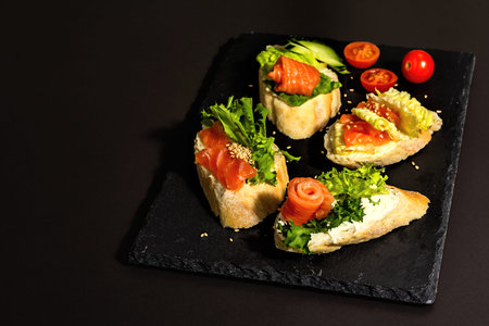 Assorted open sandwiches with salted salmon, cream cheese, salad leaves and cucumber. Seafood,...