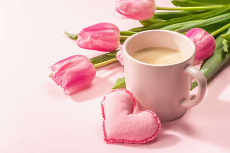 Romantic flat lay composition with a cup of coffee, soft felt hearts, and fresh tulips. Valentines or Mother's Day, Wedding, good morning concept. White wooden background, copy spaceの写真素材