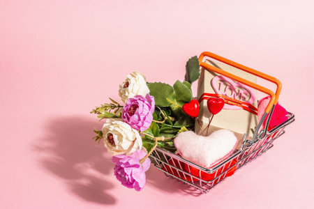 Spring Sale concept isolated on pink background. Shopping basket with festive gifts and traditional Valentine's Day decor. Trendy hard light, dark shadow. Flat lay, mockup, templateの写真素材